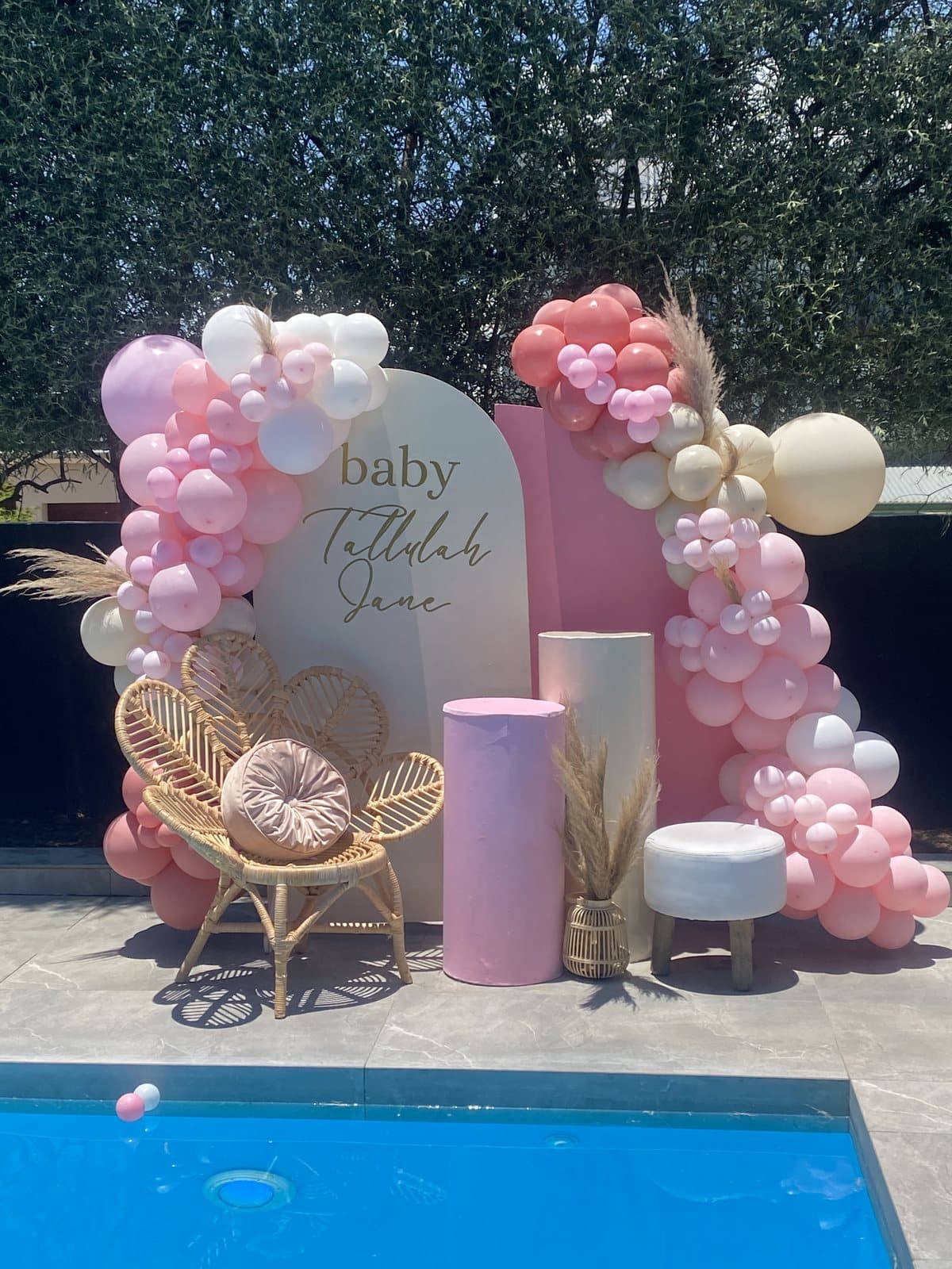 Pastel balloon arch by the pool for a baby shower