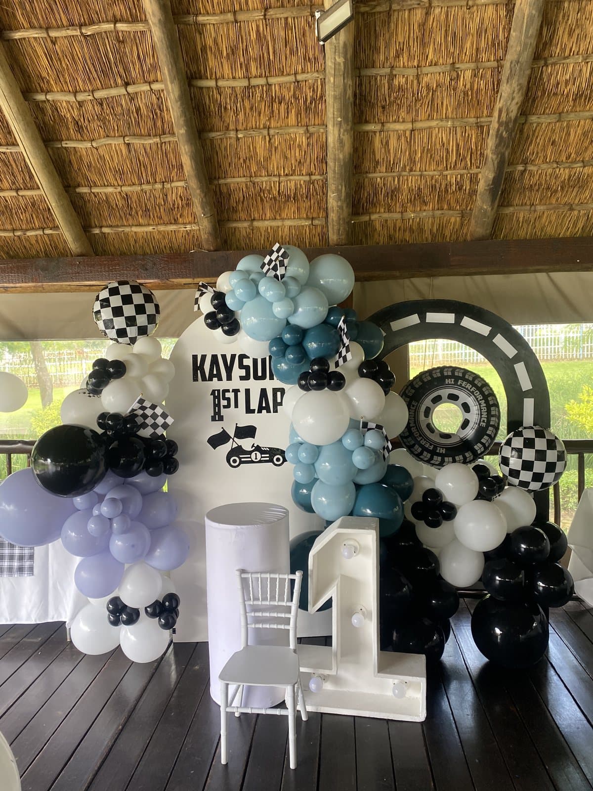 Black and white checkered racing themed balloon columns for a first birthday party