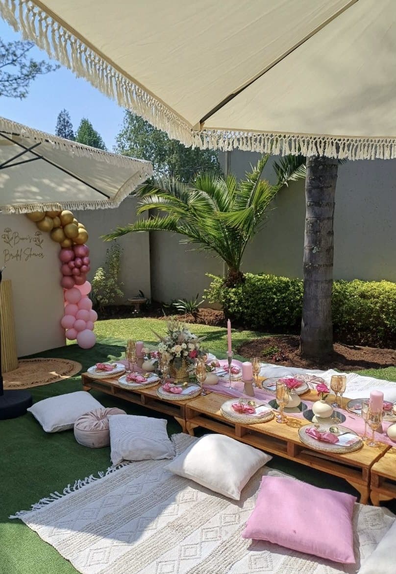 Intimate picnic style low table setup with pastel pillows outdoors